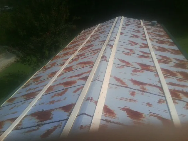 Rusted metal roof panels with new wood purlins before replacement — Storm Damage Roof Repair in Bradenton Beach by Roofing Brothers