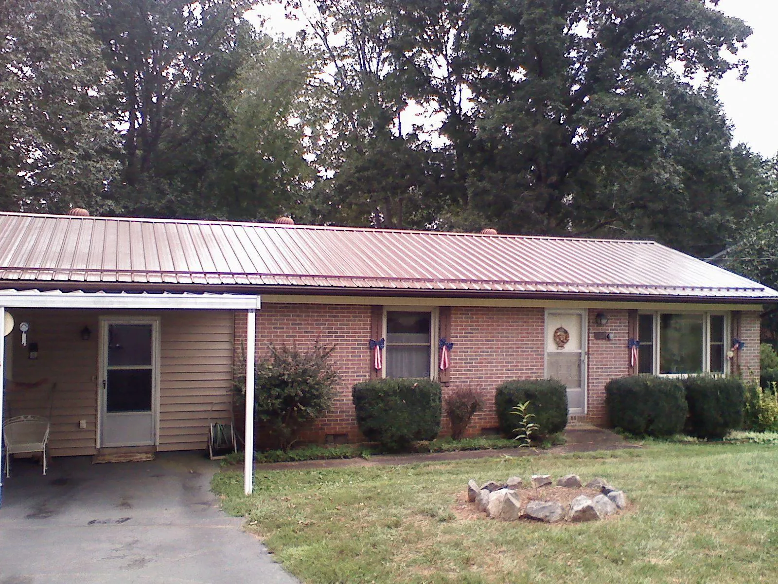 Bronze metal roof and carport on a brick ranch home — Roof Repair work by our crew in Bradenton Beach